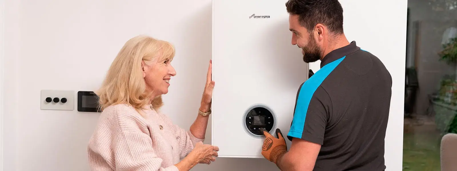 British gas engineer looking at boiler at customer's house