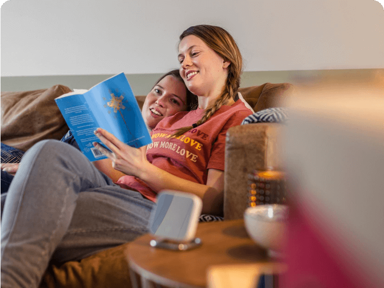 Hive Home customers reading a book in their lounge with a Hive Thermostat Mini in the foreground