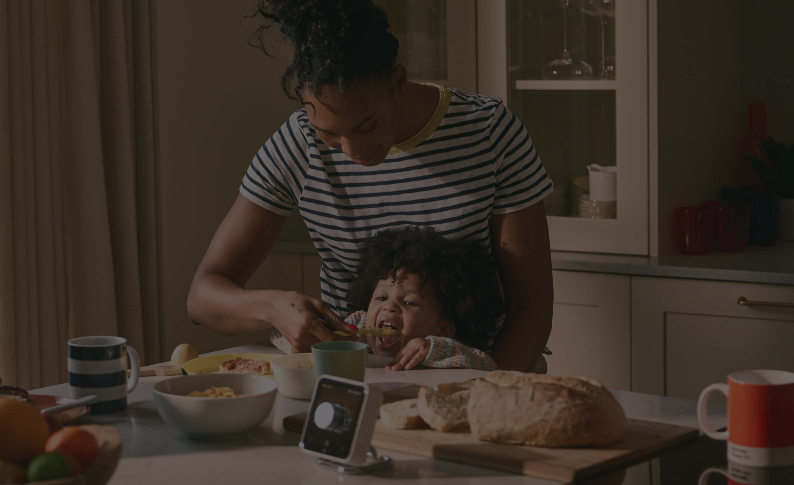 Hive Thermostat in the kitchen with a mother and child cooking