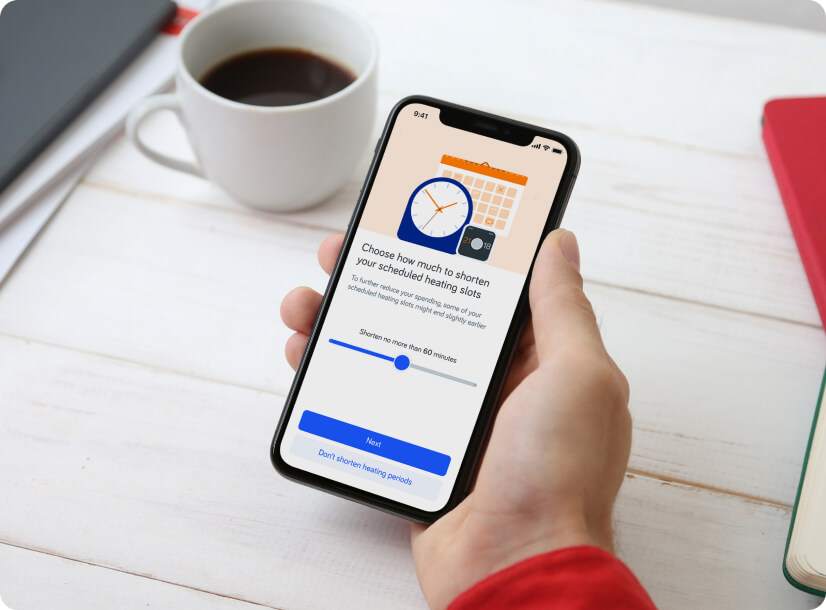 A Hive customer holding a phone, using the Hive App to shorten his scheduled heating time slots.